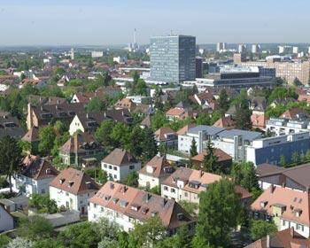 Blick auf Erlangen - 

�HighTech.HighMed.HighSpeed.� ist Motto der Gro�stadt Erlangen. Als Standort der Siemens AG, der zweitgr��ten Universit�t Bayerns und als Standort f�r Kliniken und medizinische Einrichtungen hat sich Erlangen einen Namen gemacht. 
Erstmals im Jahr 1002 urkundlich erw�hnt, war Erlangen 1686 ein Zufluchtsort geflohener calvinistischer Hugenotten aus Frankreich. Markgraf Christian Ernst von Brandenburg-Bayreuth siedelte die Glaubensfl�chtlinge in Erlangen an. 

Die Hut- und Handschuhmacher, Strumpfwirker und H�ndler bescheren der Stadt im 18. Jahrhundert die erste gro�e wirtschaftliche Bl�te. Als bayerische Metropole f�r Exportbier erlangt sie im Jahrhundert danach Weltgeltung. Vor rund 80 Jahren tritt die Erfindung des Bleistiftspitzers von hier aus ihren Siegeszug um den Globus an.

Nach dem Zweiten Weltkrieg werden mit der Ansiedlung der Siemens-Schuckert-Werke die Weichen f�r eine gesamtst�dtische Entwicklung in Richtung Zukunft gestellt. Aus der mittelfr�nkischen Kleinstadt wird die Gro�stadt mit moderner Industrie, leistungsf�higen Dienstleistungs- und Einzelhandelsunternehmen und (seit 1974) �ber 100.000 Einwohnern.
 